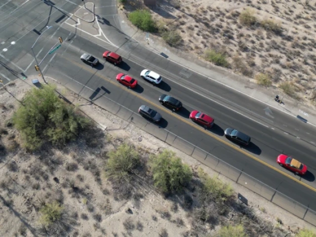 an overhead view of an intersection with cars with a person sitting near the intersection in a lawn chair